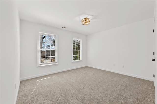 unfurnished room featuring carpet and baseboards