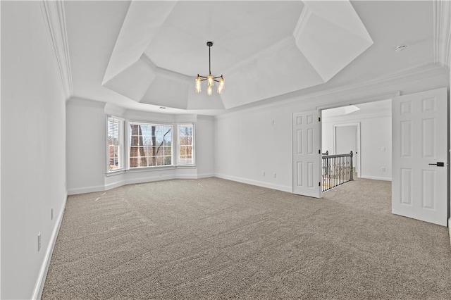 carpeted spare room with a chandelier, baseboards, crown molding, and a tray ceiling