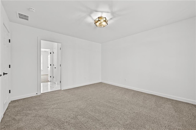 empty room with visible vents, baseboards, and carpet