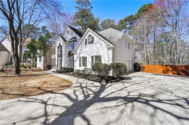 view of front facade with a garage, stucco siding, and fence