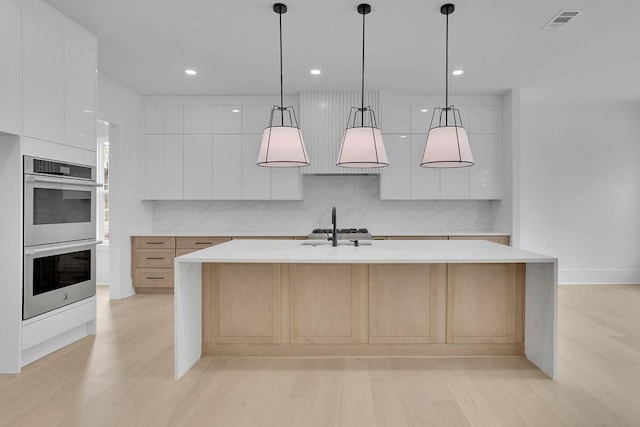 315 Hillcrest View Dr, Suwanee, GA 30024 - kitchen with stainless steel double oven, modern cabinets, light wood-style flooring, backsplash, and light countertops
