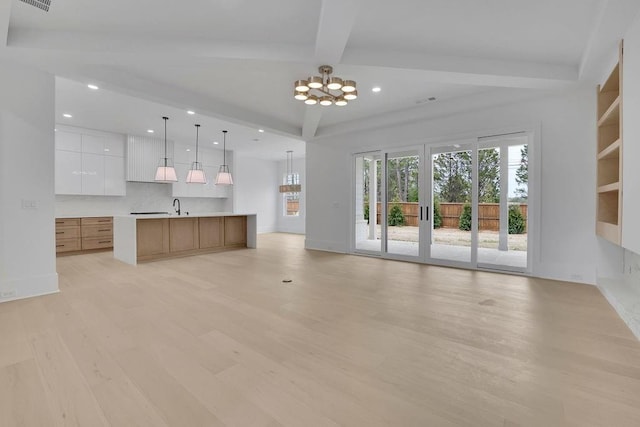 315 Hillcrest View Dr, Suwanee, GA 30024 - unfurnished living room featuring a sink, light wood-style floors, a chandelier, beam ceiling, and recessed lighting