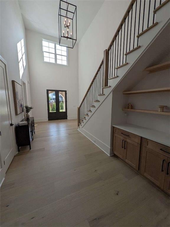 315 Hillcrest View Dr, Suwanee, GA 30024 - entryway featuring light wood-style flooring, stairs, a high ceiling, a chandelier, and baseboards