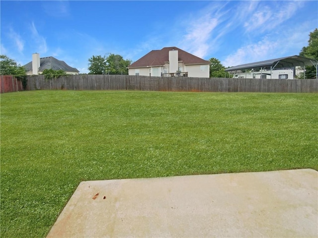 rear view of property featuring a chimney, a yard, a patio area, and a shingled roof