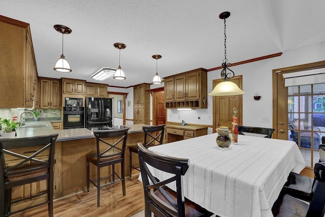 dining room with light wood-type flooring and crown molding
