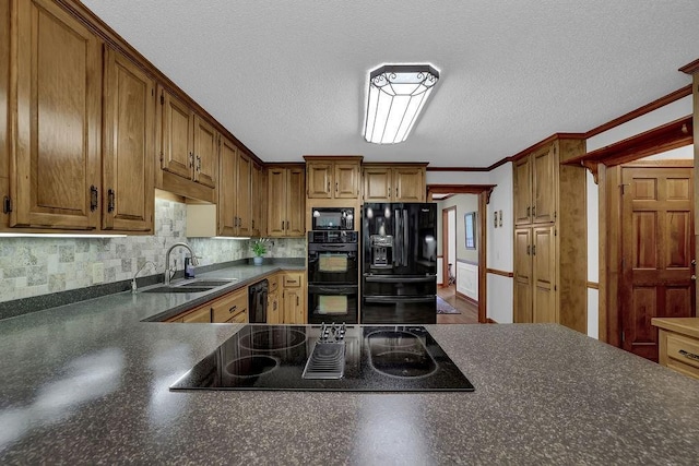 kitchen with black appliances, dark countertops, a sink, backsplash, and ornamental molding