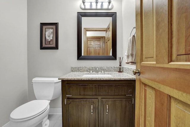 half bath with baseboards, toilet, tile patterned floors, and vanity