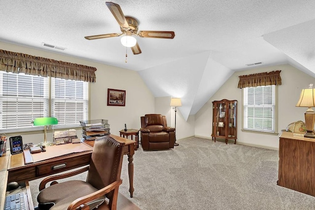 carpeted office space featuring ceiling fan, lofted ceiling, a textured ceiling, and baseboards