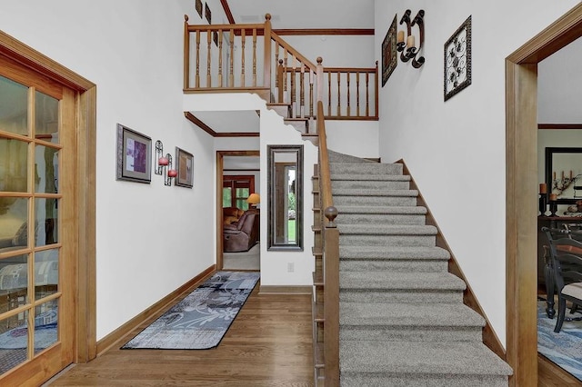 entrance foyer featuring wood finished floors, stairs, ornamental molding, and baseboards