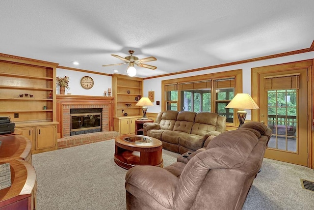 carpeted living room featuring ornamental molding, plenty of natural light, ceiling fan, a brick fireplace, and a textured ceiling