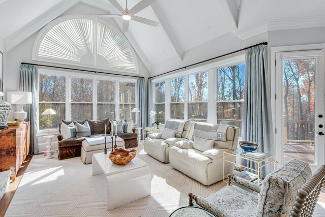 sunroom featuring a wealth of natural light, ceiling fan, and lofted ceiling with beams