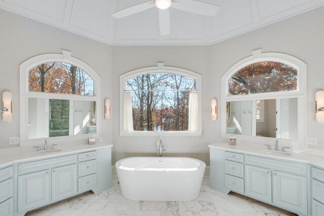 bathroom with a washtub, ceiling fan, vanity, and a wealth of natural light