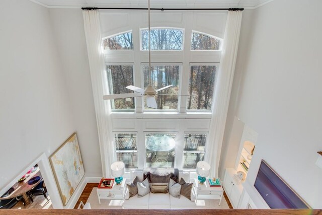 living room with hardwood / wood-style flooring, plenty of natural light, ornamental molding, and ceiling fan