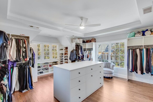 spacious closet featuring ceiling fan, light hardwood / wood-style floors, and a raised ceiling