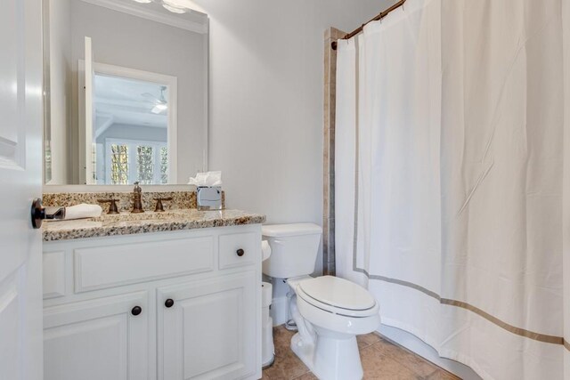 bathroom featuring toilet, vanity, tile patterned floors, and ornamental molding