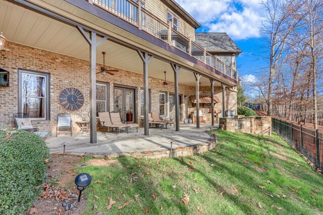 rear view of house featuring a lawn, ceiling fan, a balcony, and a patio