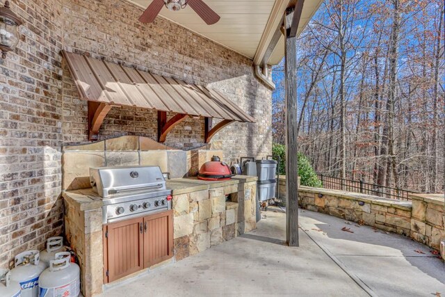 view of patio with an outdoor kitchen, ceiling fan, and grilling area