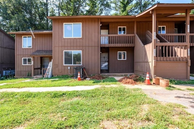 view of front of house with a front lawn and cooling unit