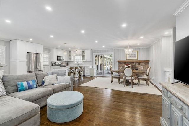 living room with dark wood-type flooring, plenty of natural light, recessed lighting, and crown molding