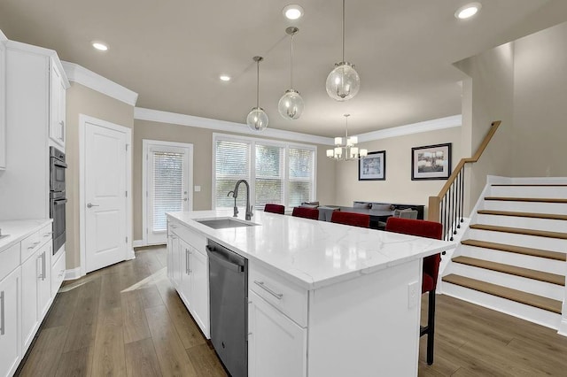 kitchen featuring white cabinetry, sink, a breakfast bar area, a kitchen island with sink, and stainless steel appliances