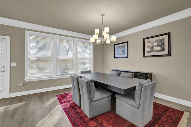 dining room with dark hardwood / wood-style flooring, a notable chandelier, and ornamental molding