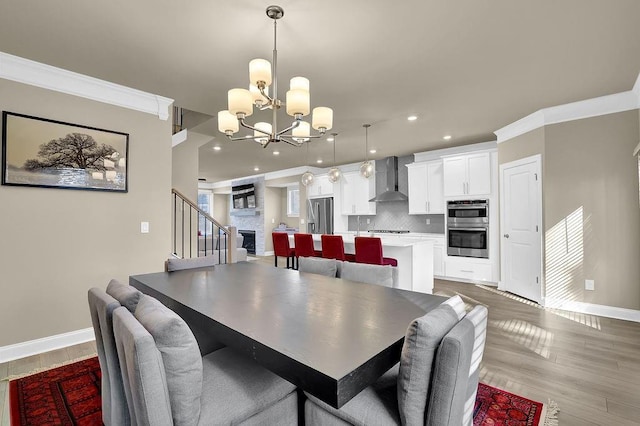 dining area featuring hardwood / wood-style flooring, ornamental molding, and a notable chandelier