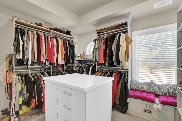 walk in closet featuring light colored carpet