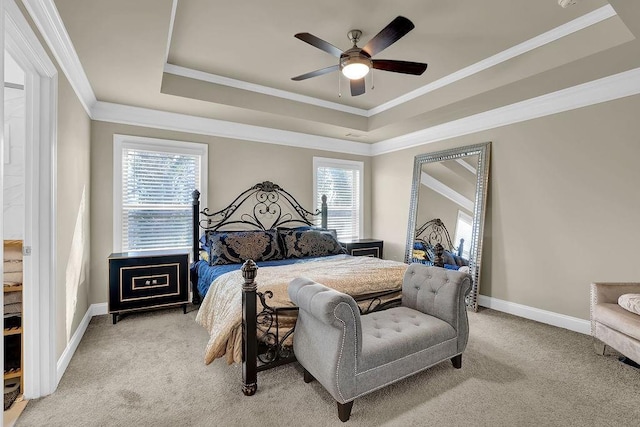 carpeted bedroom with crown molding, ceiling fan, and a raised ceiling