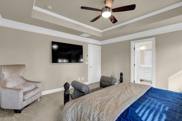 bedroom with connected bathroom, carpet flooring, ceiling fan, a tray ceiling, and crown molding