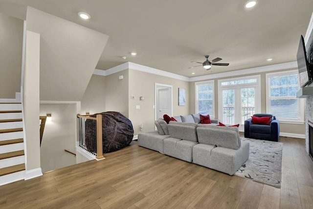 living room featuring crown molding, light hardwood / wood-style floors, and ceiling fan