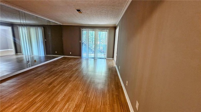 2388 Lawrenceville Hwy Unit D, Decatur, GA 30033 - unfurnished room featuring crown molding, wood finished floors, baseboards, and a textured ceiling