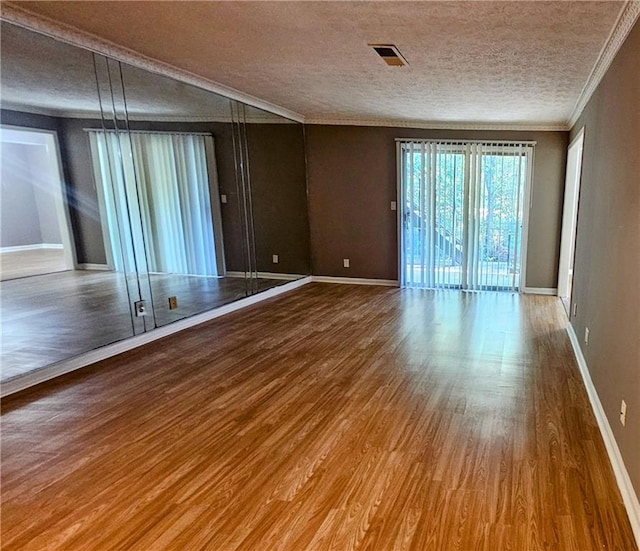 2388 Lawrenceville Hwy Unit D, Decatur, GA 30033 - unfurnished room with crown molding, baseboards, wood finished floors, and a textured ceiling
