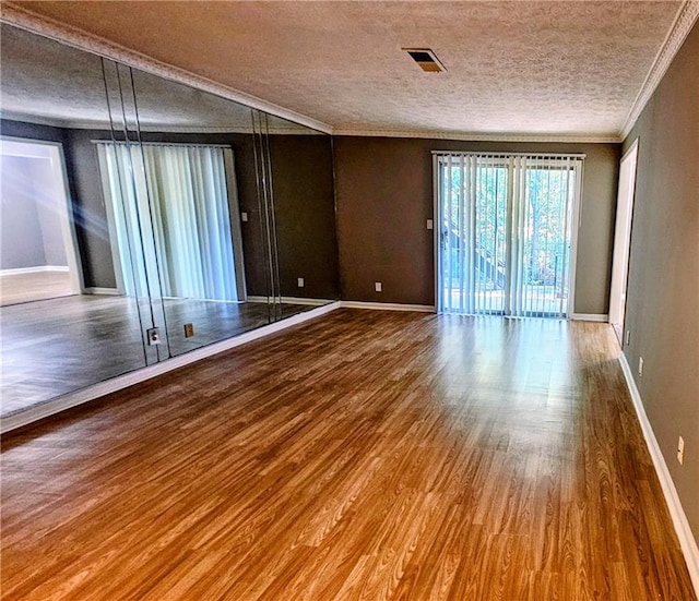 2388 Lawrenceville Hwy Unit D, Decatur, GA 30033 - spare room featuring baseboards, a textured ceiling, ornamental molding, and wood finished floors