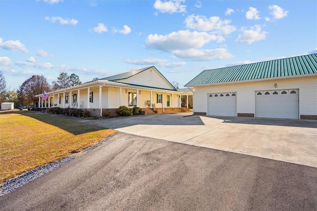 view of front of property featuring a front lawn, a porch, and a garage