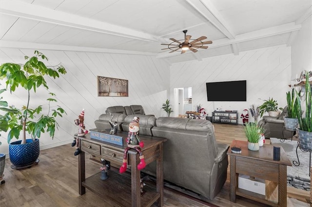 living room featuring ceiling fan, hardwood / wood-style floors, beamed ceiling, and wooden walls