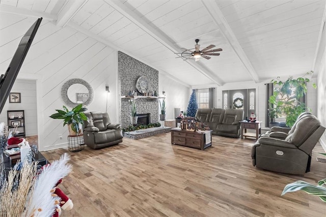 living room featuring ceiling fan, beamed ceiling, and hardwood / wood-style flooring