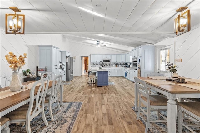 dining room featuring sink, wooden ceiling, lofted ceiling with beams, light hardwood / wood-style floors, and ceiling fan with notable chandelier