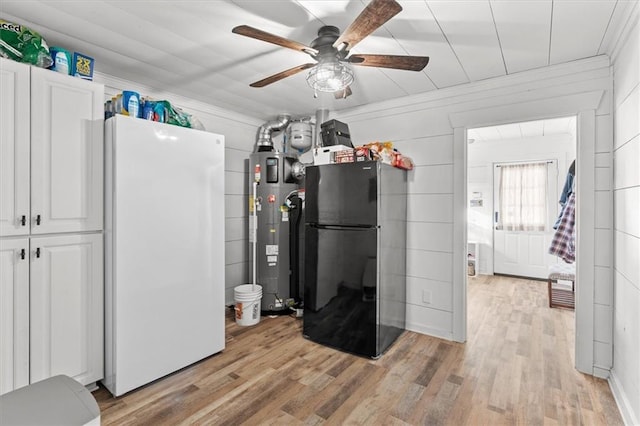 kitchen with white cabinets, black refrigerator, light wood-type flooring, water heater, and white fridge