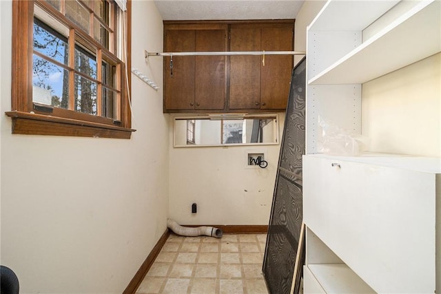 clothes washing area with laundry area, light floors, baseboards, and washer hookup