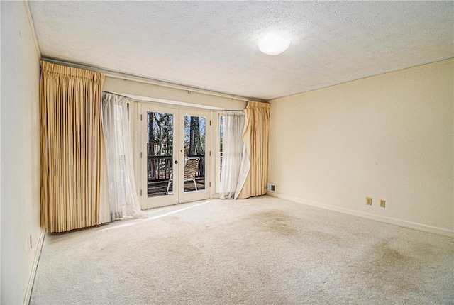 unfurnished room with french doors, baseboards, a textured ceiling, and carpet flooring