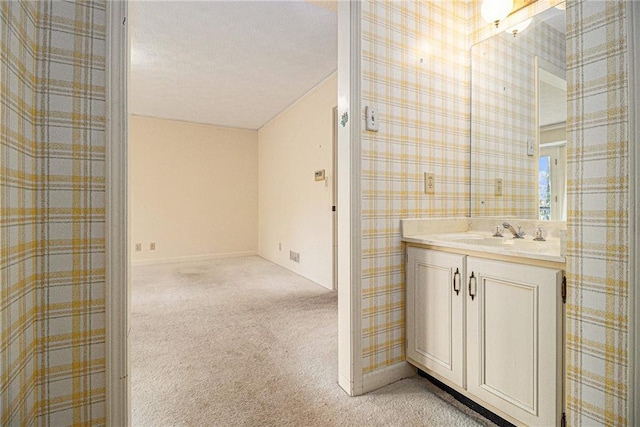 bathroom with wallpapered walls and vanity