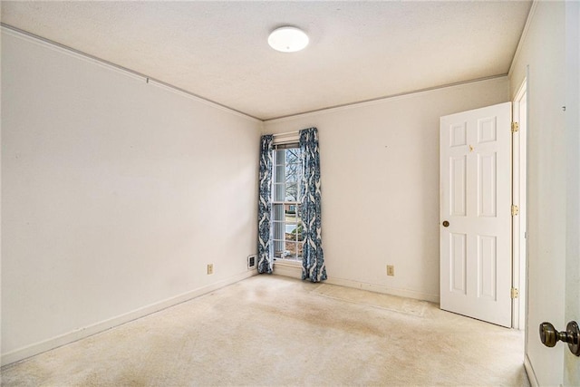 spare room featuring carpet and baseboards