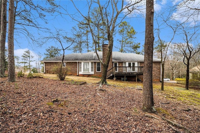 exterior space with brick siding and a deck