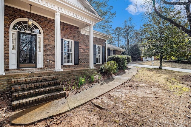 doorway to property featuring brick siding