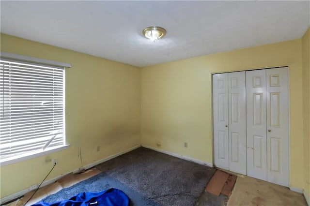 9550 Canvasback Ct, Jonesboro, GA 30238 - unfurnished bedroom with carpet floors, a closet, baseboards, and multiple windows