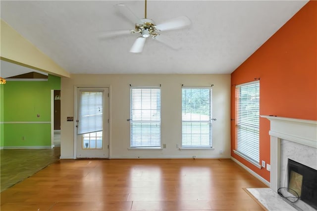 9550 Canvasback Ct, Jonesboro, GA 30238 - unfurnished living room featuring vaulted ceiling, a high end fireplace, wood finished floors, ceiling fan, and baseboards