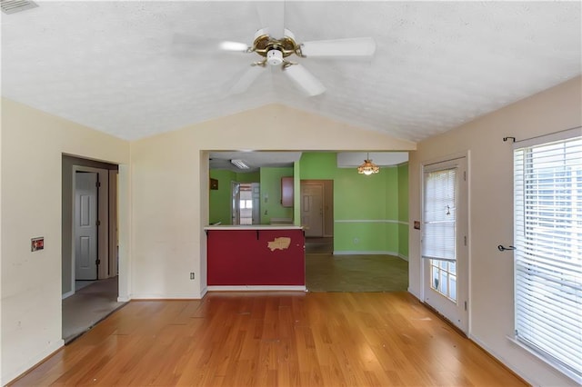 9550 Canvasback Ct, Jonesboro, GA 30238 - unfurnished living room with ceiling fan, wood finished floors, lofted ceiling, baseboards, and a textured ceiling
