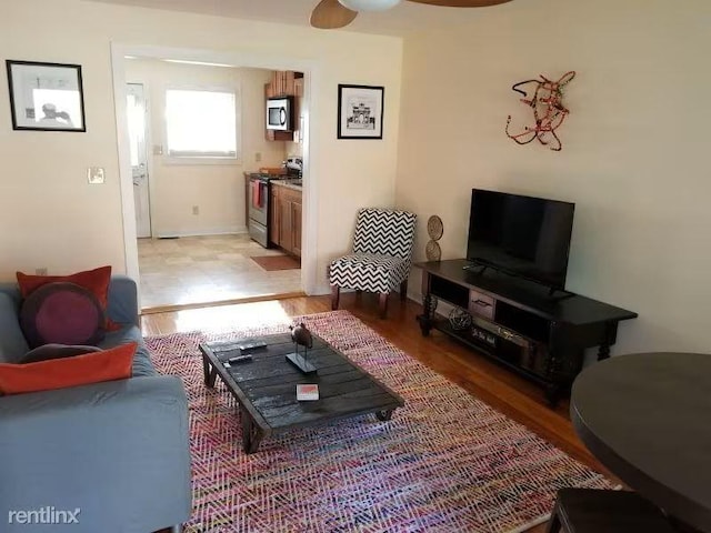 living room with ceiling fan and light hardwood / wood-style floors