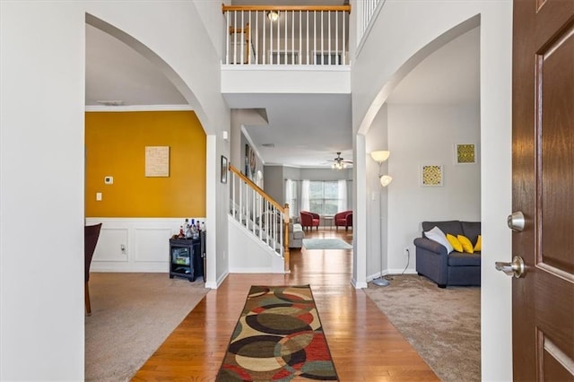 foyer with wood-type flooring, ceiling fan, and ornamental molding