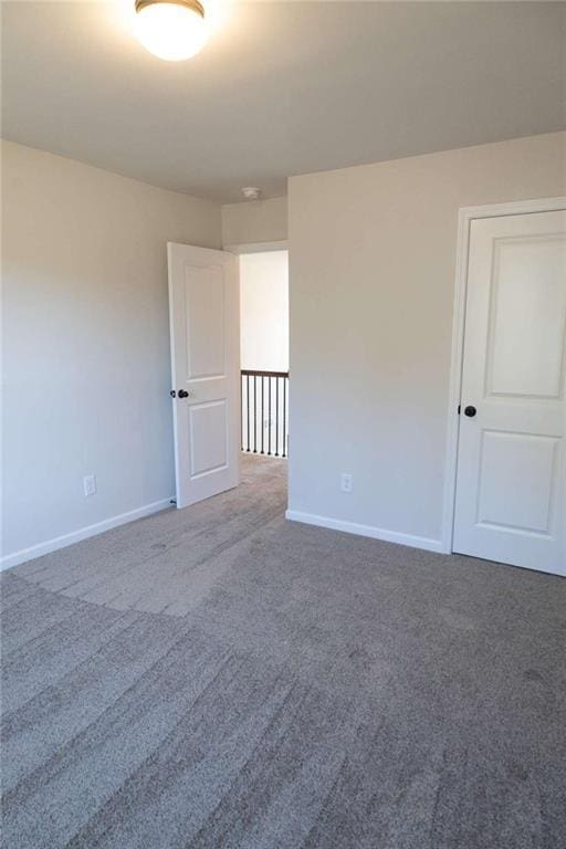 carpeted empty room with baseboards